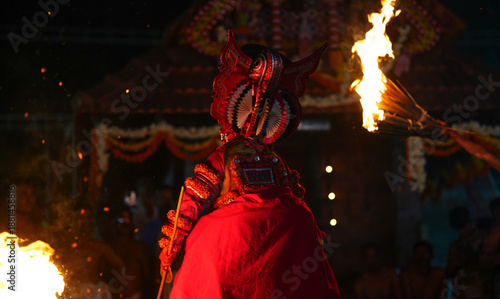 Wallpaper Mural Theyyam artist dancing through fire during a sacred ritual performance in Kerala, India. This powerful moment represents faith, Torontodigital.ca