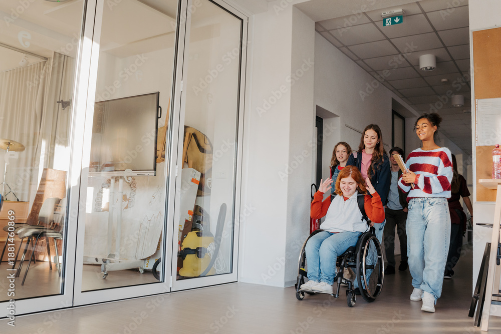 Fototapeta premium Teen students in school hallway, girl in wheelchair.
