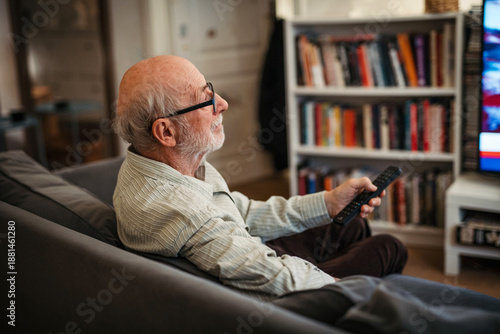 Tableau sur toile Elderly man watching television alone at home.