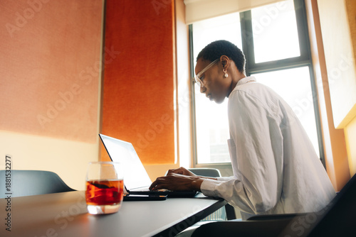Focused professional working on laptop in contemporary office environment
