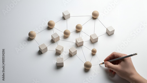 Network of wooden blocks concept — hand connecting nodes to form a collaborative grid

