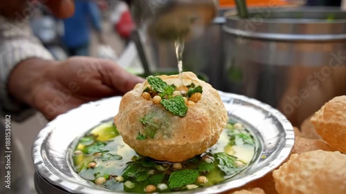 Close-up of a street food vendor preparing and serving traditional Indian Pani Puri with spicy flavored water