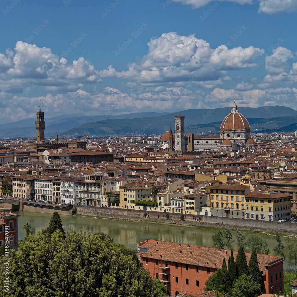 Obraz premium The Arno River winds through Florence, with the grand silhouette of Santa Maria del Fiore Cathedral and the Tower of the Old Palace standing prominently in the city’s historic skyline.
