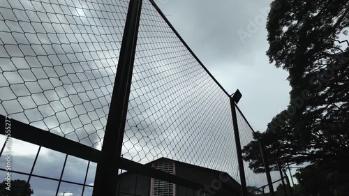 Chain Link Fence and Overcast Sky - Urban Landscape View.