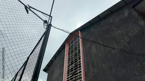 Exterior Building View with Fence and Light Fixture on Overcast Day.