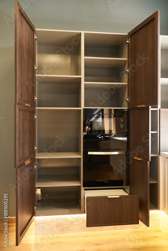 Tableau sur toile Modern built-in wardrobe with open doors, shelves and appliances.