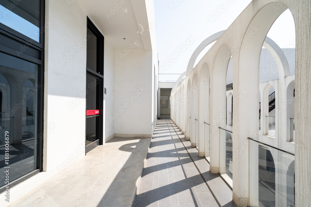 Naklejka premium White arched architectural corridor under blue sky