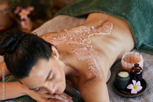 фотографія Woman enjoying body scrub on back at luxury spa