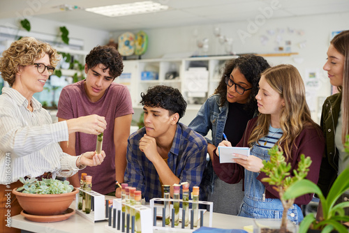 фотографія Teacher showing science experiment to class at high school