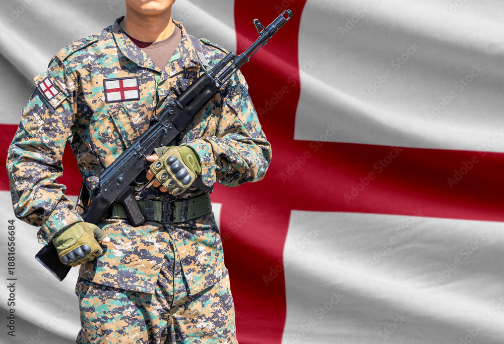 Fototapeta premium Saint George flag with soldier in military uniform holding assault rifle in front of it
