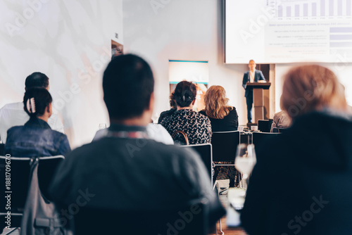Speaker giving a talk in conference hall at business event. Rear view of unrecognizable people in audience at the conference hall. Business and entrepreneurship concept
