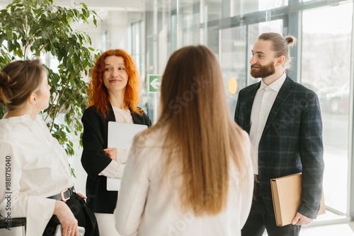 Fotografie Business colleagues conversing in modern office corridor