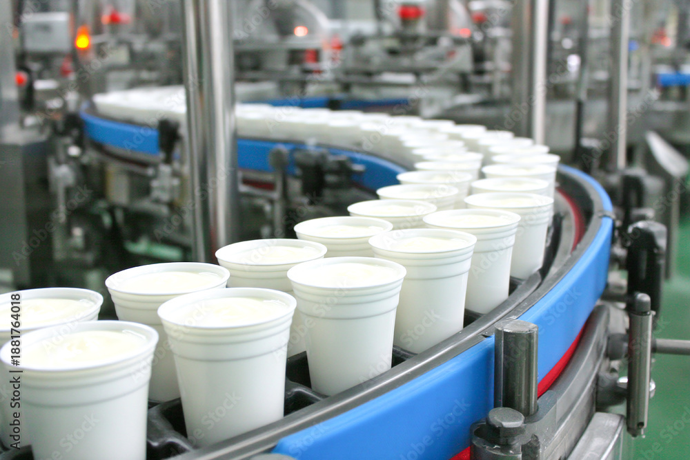 Obraz premium Production line fills small cups on conveyor belt in factory setting Generative AI