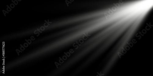Long soft white light rays shining from the top on black background. Dramatic abstract light beams effect.