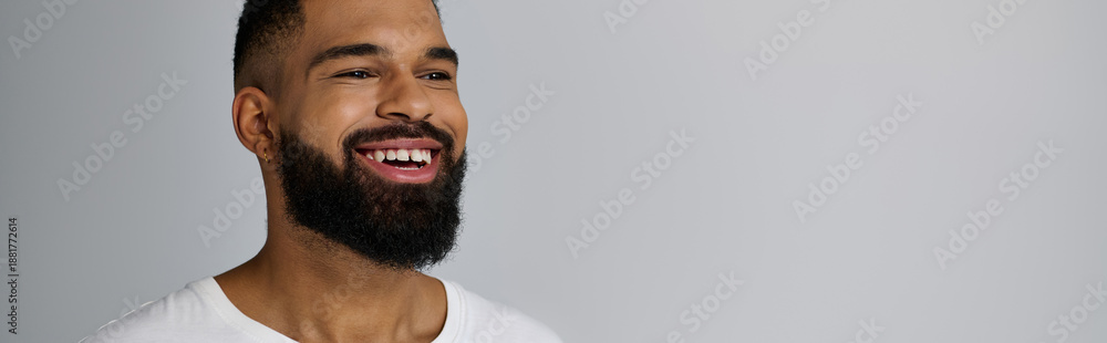 Fototapeta premium Handsome young African American man smiles in studio showcasing skin care routine