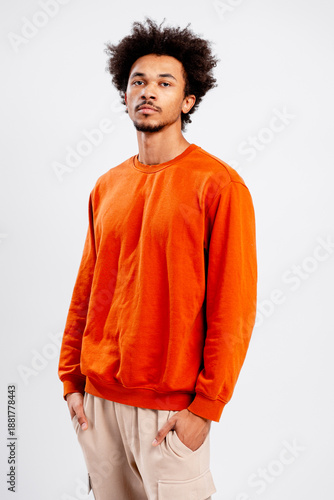 Foto Young man standing in a studio, confidently posing, wearing trendy casual street