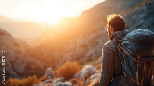 Man backpacker hiking mountain at sunset. Adventure travel concept for tourism blog. Back view of male traveler enjoying wilderness nature.