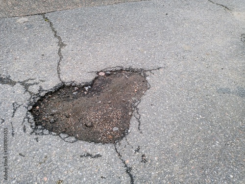 a hole in the asphalt in the shape of a heart. love on the asphalt. a pothole on the asphalt. road repair. a problem with the road surface. road work. valentine's day.
