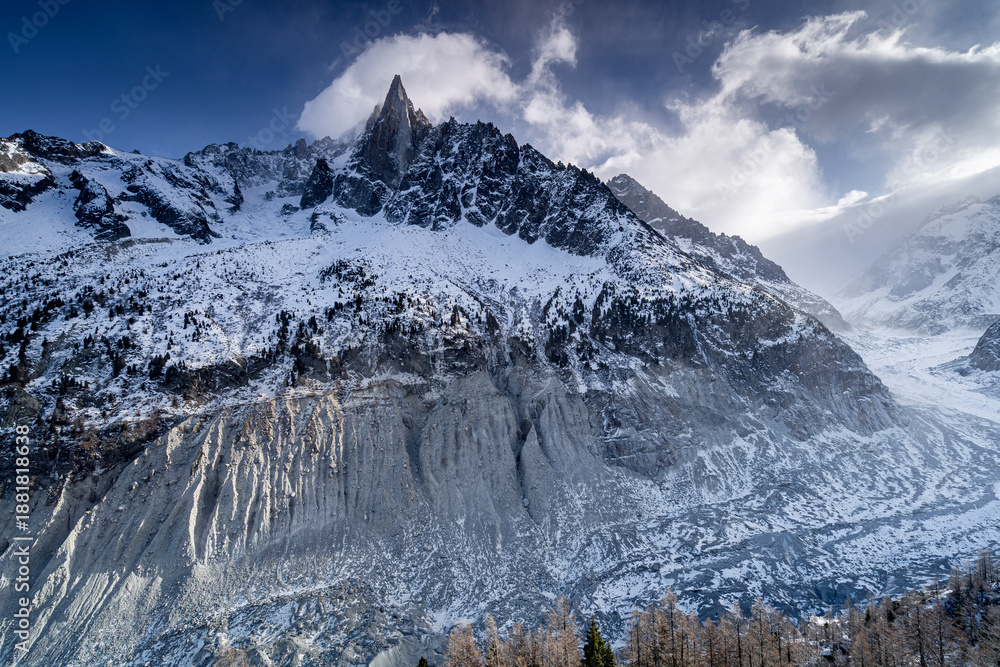 Obraz premium Majestic Alpine peak Aiguille du Petit Dru in winter with beautiful climbing wall and Mer de Glace glacier, Chamonix-Mont-Blanc, France.