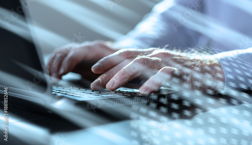 Hands of businessman using laptop, close up; light effect