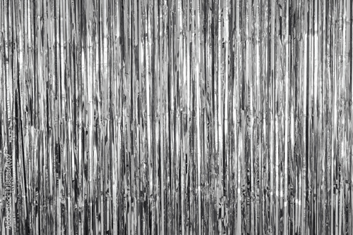Fotografía Shiny silver fringe curtain background with vertical metallic strands reflecting light