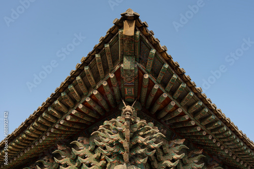Foto Ornate roof of a traditional building with intricate details, featuring a carved dragon motif against the sky