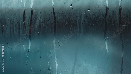 Fotografía Window pane covered in condensation and raindrops, creating a blurred, abstract