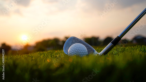 Golf clubs and balls on a green lawn in a beautiful golf course with morning sunshine.