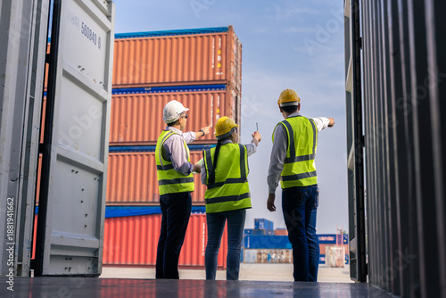 Team of workers discussing logistics operations at container yard