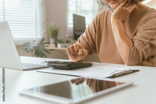 senior couple and documents with laptop for finance, budget planning or retirement annuity on sofa. Elderly man, woman or house with smile, computer or paperwork for pension fund or insurance