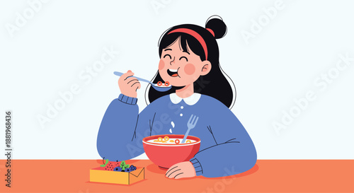 Happy young girl with dark hair and a blue sweater enjoying a bowl of cereal and fresh fruit for breakfast at a table.