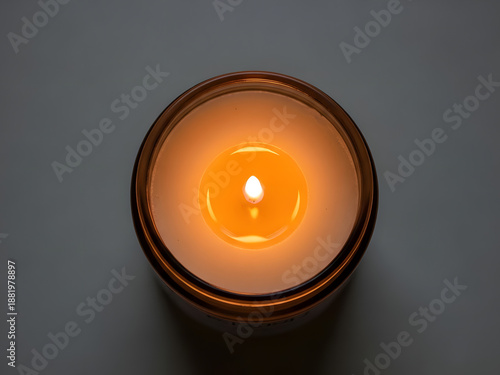 Top view of a lit candle in a glass jar on a transparent background