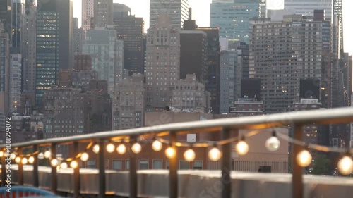 Wallpaper Mural New York City Manhattan Midtown skyline from Queens, United States. Skyscraper buildings architecture, cityscape from rooftop in Long Island, Hunters Point. Light bulbs garland on roof, urban sunset. Torontodigital.ca