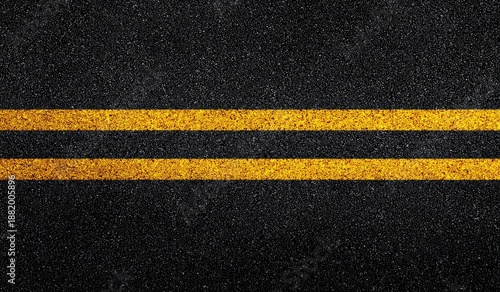 Close-up view of asphalt road with two bright yellow lane markings