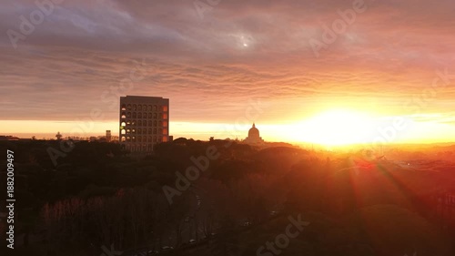 Aerial view of the Palazzo della Civiltà Italiana (Square Colosseum) at golden hour sunset. Drone flight over the EUR district in Rome, Italy, featuring rationalist architecture.