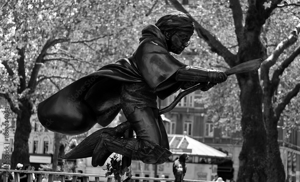 Fototapeta premium LONDON UNITED KINGDOM 06 19 2023: Harry Potter statue sculpture depicts Harry, flying on his broom thingy.A fun stop on the movie statue trail around Leicester square
