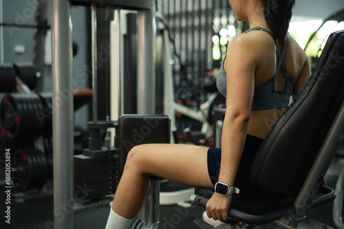 Obraz na plátně Side view Closeup woman exercising inner thigh muscles on a fitness machine