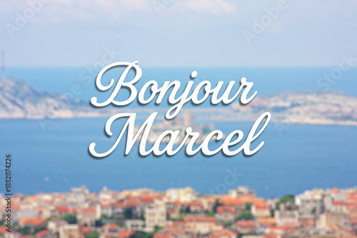Fotografie A blurred view of the coastal city of Marseille and the Mediterranean Sea; in the foreground, the inscription Bonjour Marcel in large font