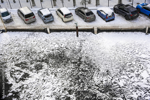 Bild auf Leinwand Top view of snow covered cars in street parking lot during winter