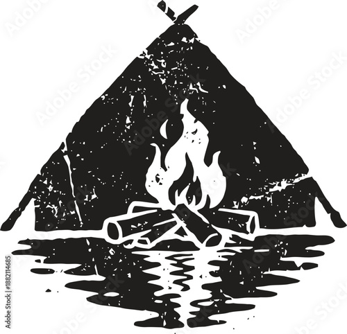 Rustic black and white campfire with logs burning in front of tent silhouette reflection on water