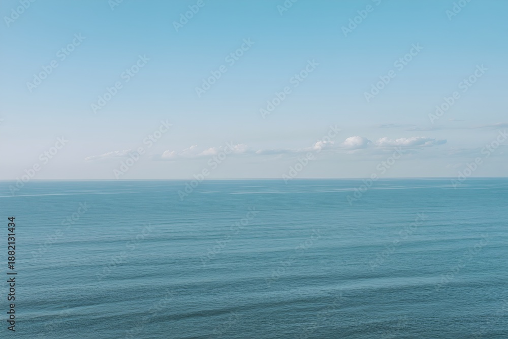Obraz premium Calm ocean waves in serene blue tones with soft natural lighting for tranquil seascape background