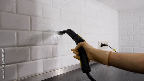 Φωτογραφία Person cleaning kitchen wall tiles with steam cleaner