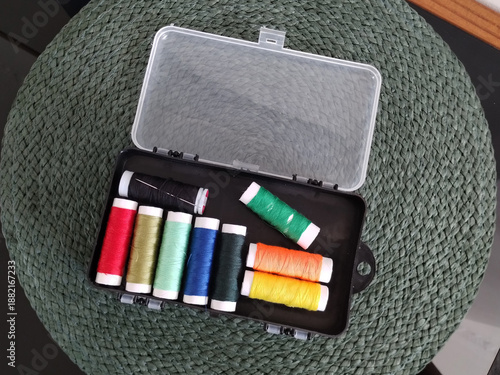 Some spools of sewing thread in assorted colors are inside the box