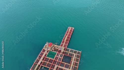 Workers tend to mussel farms in the sea, managing ropes and nets used to grow shellfish during the day in a coastal setting.