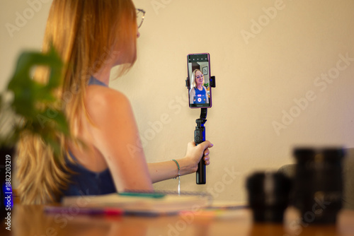Foto jovem influenciadora segurando celular e gravando vídeos para redes sociais
