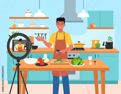 A man in an apron filming a cooking video in a modern kitchen with a smartphone on a tripod and ring light, preparing fresh vegetables.