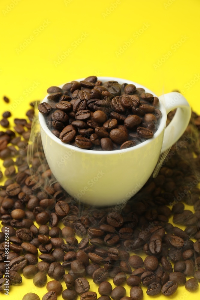 Fototapeta premium Aromatic coffee beans and cup on yellow background, closeup