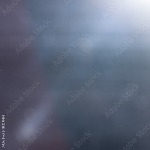 Abstract dark blue and grey bokeh background with soft moody light gradients