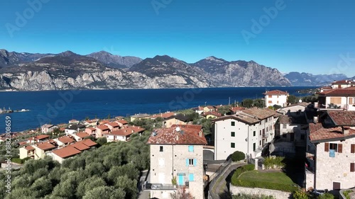 Wallpaper Mural Drone flight over a small Italian village near Brenzone on Lake Garda. Stone houses, bright blue water, mountains and clear sky create a vivid Mediterranean landscape. Torontodigital.ca