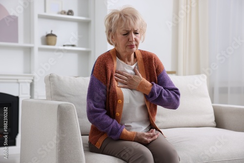 Photos Heart attack. Senior woman suffering from pain in chest indoors